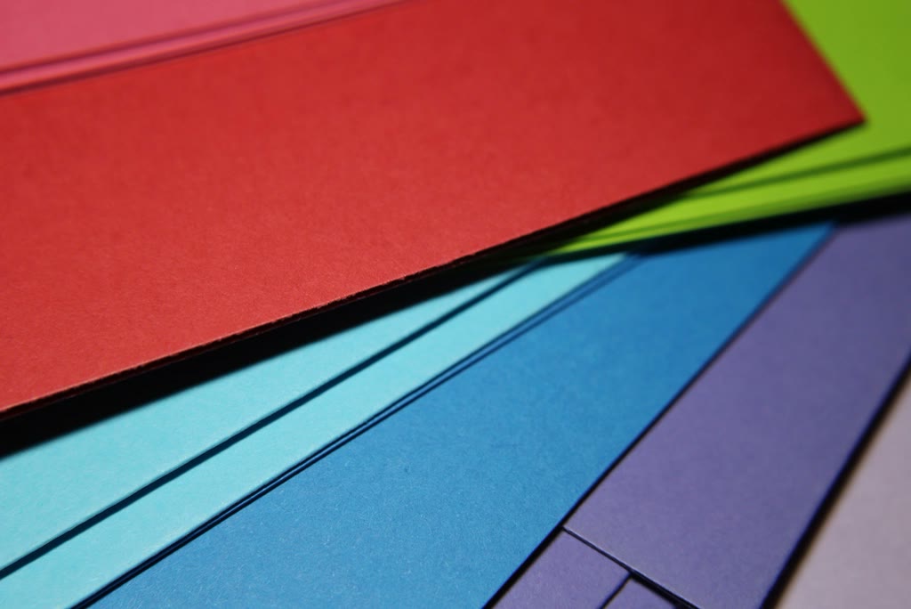 Folhas de papel vermelho, verde, azul e roxo sobrepostas