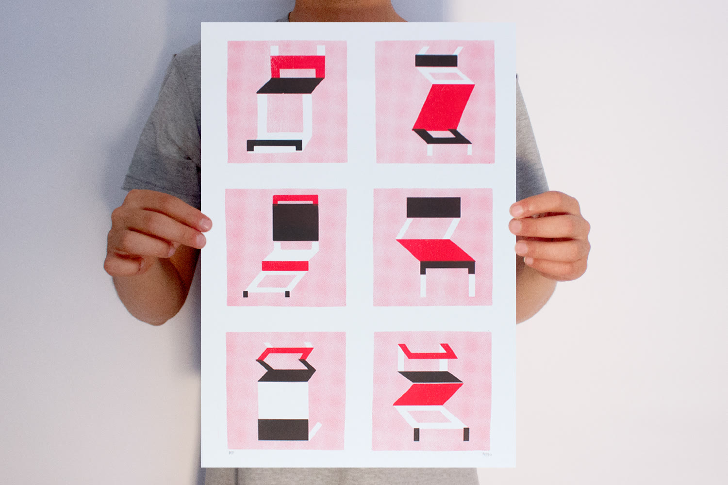 Cartaz impresso em duas cores, rosa e preto, segurado com as duas mãos